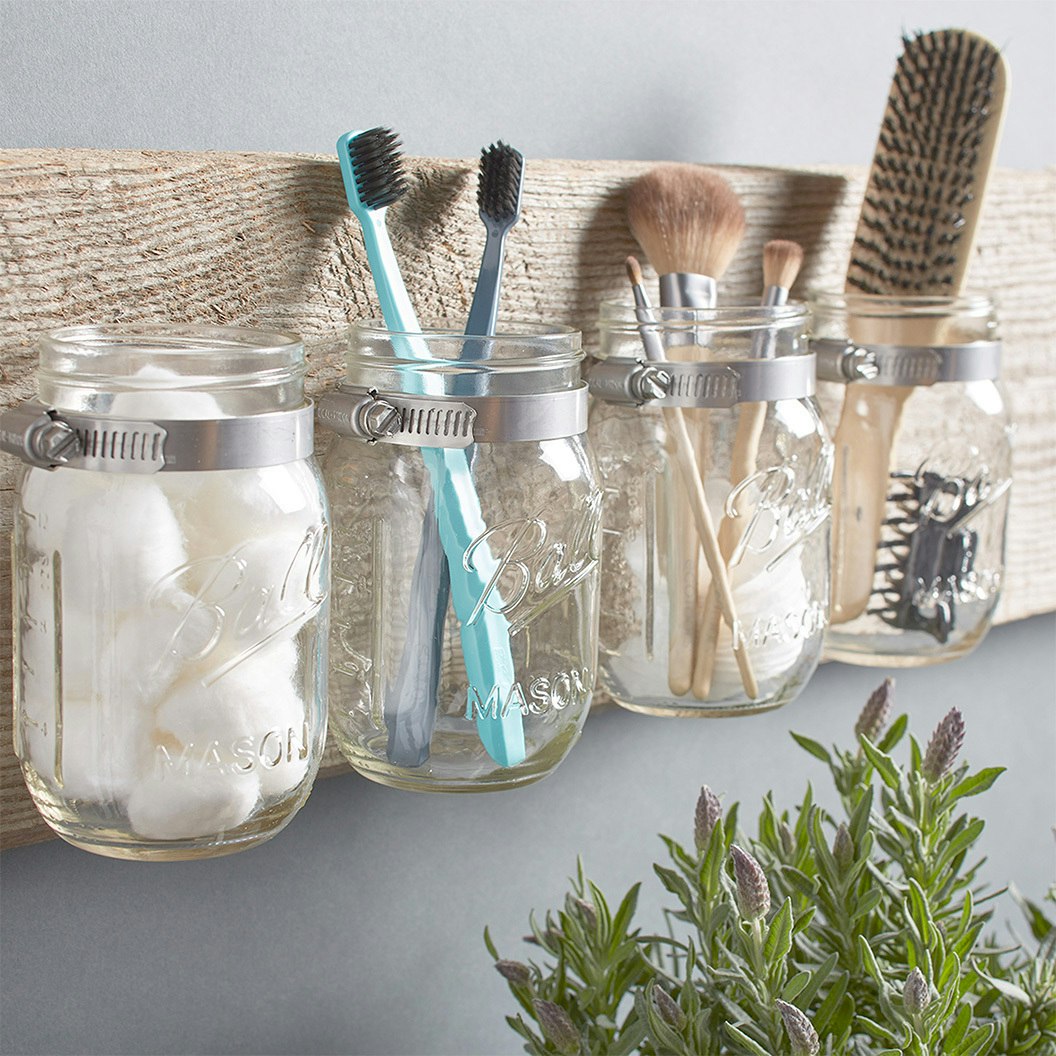 Household items for hygiene in hanging mason jars in bathroom