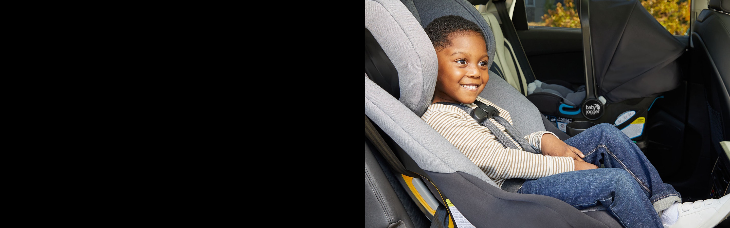 smiling child sitting in car seat in car