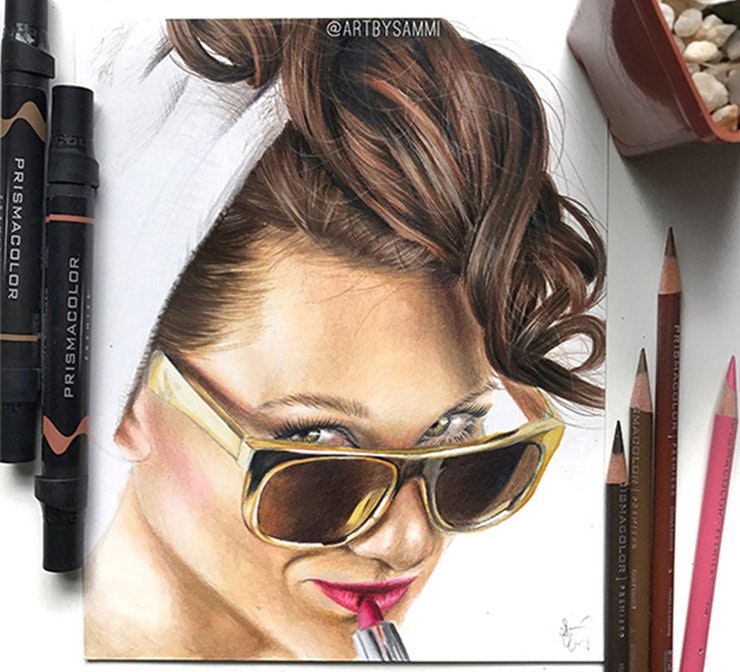 Prismacolor markers and colored pencils next to portrait drawing